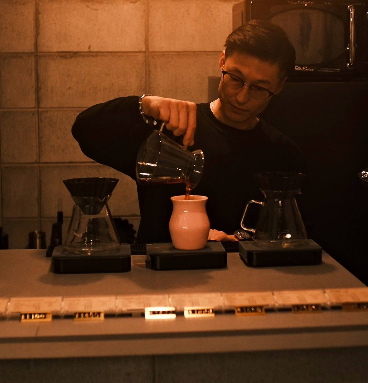 抽出したコーヒーをカップに注ぐバリスタ